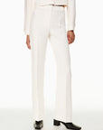 Model wearing Siamo Firenze white Contour Flare Pants with a structured high-waist fit, center crease, and soft flare, styled with black square-toe boots.